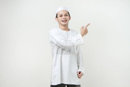 Foto de Feliz asiático musulmán hombre dar ponting dedo gesto. Gente religiosa Islam concepto de estilo de vida. celebración Ramadán y ied Mubarak. sobre fondos aislados - Imagen libre de derechos