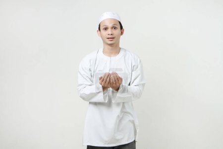 Foto de Hombre musulmán asiático con gesto de oración en la mano. sosteniendo la palma hacia arriba. Gente religiosa Islam concepto de estilo de vida. celebración Ramadán y ied Mubarak. sobre fondos aislados - Imagen libre de derechos