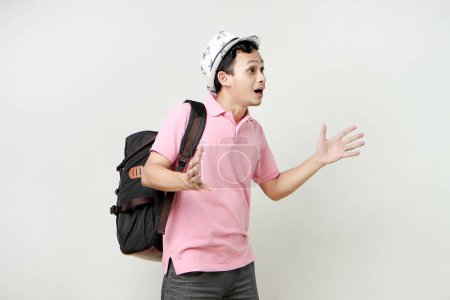 Foto de Hombre asiático mochilero con expresión sorprendido y sorprendido. nómada digital y concepto de viaje. sobre fondo aislado - Imagen libre de derechos