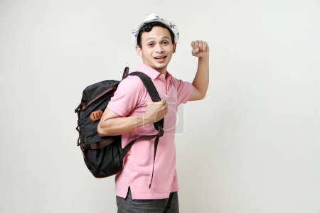 Foto de Hombre asiático mochilero mostrando gesto de fuerza con los brazos. nómada digital y concepto de viaje. sobre fondo aislado - Imagen libre de derechos
