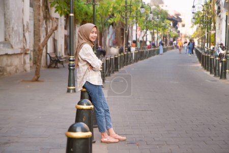 happy asian muslim woman roaming around kota lama or old city area, Semarang, Central Java , Indonesia. Traveling concept