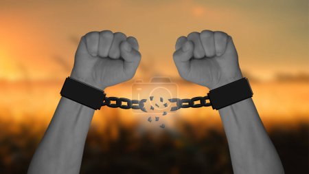 Photo for Two arms with clenched fists break the chains, with a blurred warm sunset in the background - Royalty Free Image