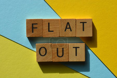Foto de Flat Out, palabras en argot australiano para Extremadamente ocupado en letras de alfabeto de madera aisladas en el fondo - Imagen libre de derechos