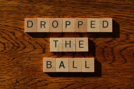 Photo for Dropped The Ball, words in wooden alphabet letters on woodgrain background - Royalty Free Image