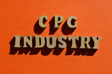 Téléchargez les photos : CPG Industry, Consumer Packaged Goods, words in wooden alphabet letters isolated on orange background - en image libre de droit