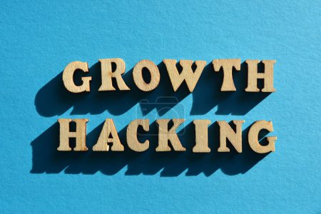 Foto de Growth Hacking, words in wooden alphabet etters isolated on blue background - Imagen libre de derechos