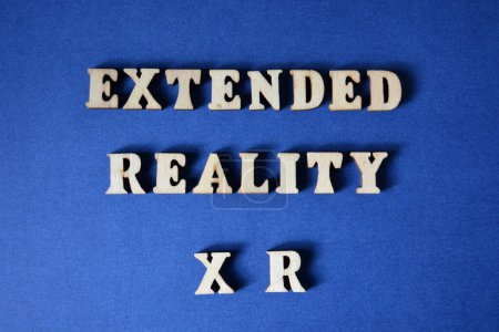 Photo for Extended Reality XR, words in wooden  alphabet letters isolated on blue background - Royalty Free Image