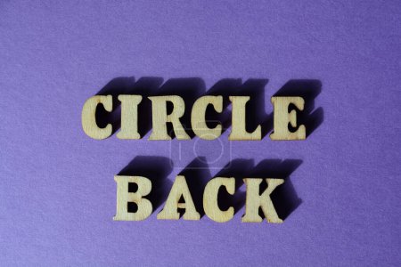 Foto de Círculo trasero, palabras en letras de alfabeto de madera aisladas sobre fondo púrpura - Imagen libre de derechos