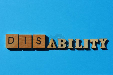 Foto de Discapacidad, Habilidad, palabra en letras de alfabeto de madera aisladas sobre fondo azul - Imagen libre de derechos