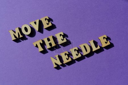 Photo for Move The Needle, words in wooden alphabet letters isolated on purple background - Royalty Free Image