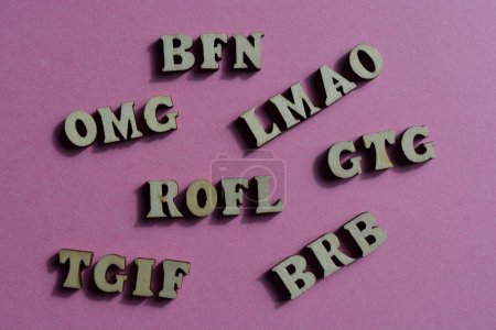 Photo for Acronyms, including BRB, Be Right Back and BFN, Bye for Now, in wooden alphabet letters isolated on pink background - Royalty Free Image