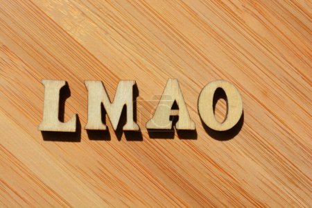 Photo for LMAO, acronym used in text speak in wooden alphabet letters isolated on bamboo background - Royalty Free Image