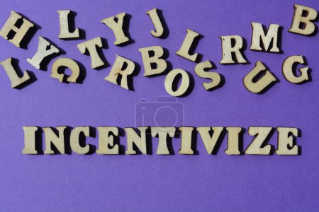 Photo for Incentivize, word in wooden alphabet letters isolated on purple background as banner headline - Royalty Free Image