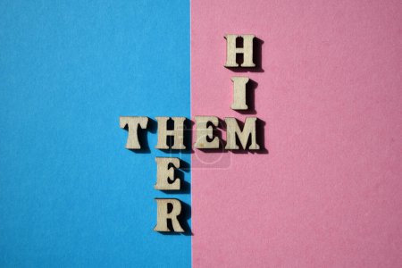 Him, Them, Her, Wörter in hölzernen Buchstaben in Kreuzworträtselform isoliert auf rosa und blauem Hintergrund