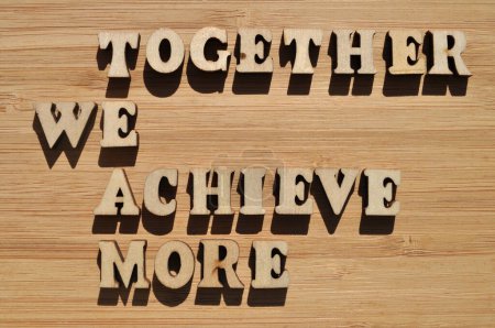 Téléchargez les photos : TEAM, Together We Achieve More, mots en lettres d'alphabet en bois isolés sur le fond comme titre de la bannière - en image libre de droit