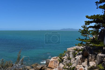 Photo for Sea view with granite rocks and hoop pines on the Gabul Way Coastal Walkway between Nelly Bay and Geoffrey Bay, Magnetic Island, Queensland, Australia - Royalty Free Image