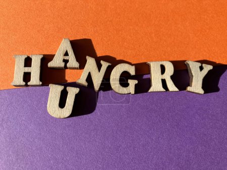 Photo for Hungry and Angry, making the blended word known as a portmanteau, Hangry. Wooden alphabet letters isolated on purple and orange background - Royalty Free Image
