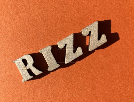 Foto de Rizz, palabra de argot para el carisma utilizado por la Gen Z, en letras de alfabeto arbolado aisladas sobre fondo naranja brillante - Imagen libre de derechos