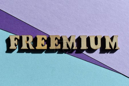 Foto de Freemium, un modelo de negocio que ofrece servicios gratuitos y de costo adicional, palabra en letras de alfabeto de madera aislada como titular de la bandera - Imagen libre de derechos