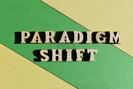 Foto de Cambio de paradigma, palabras en letras de alfabeto de madera aisladas sobre fondo verde y amarillo - Imagen libre de derechos