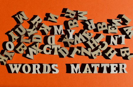 Photo for Words Matter, in wooden letters with random alphabet letters above,  isolated on orange background as banner headline - Royalty Free Image