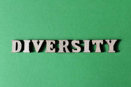 Diversidad, palabra en letras de alfabeto de madera aisladas sobre fondo verde como titular de la bandera