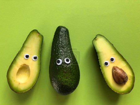 Creative healthy food concept. Avocados with googly eyes, whole and cut in half.  Making  food fun.