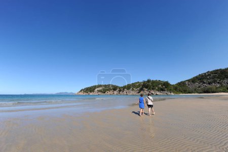 Frau und Teenager beim Spazierengehen am idyllischen tropischen Strand, Florence Bay, Magnetic Island, Queensland, Australien