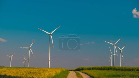 Foto de Energía renovable.Trigo maduro y molinos de viento.Energía eólica.Generadores eólicos en un campo de trigo.Concepto de electricidad y energía verde.Fuente de energía verde - Imagen libre de derechos