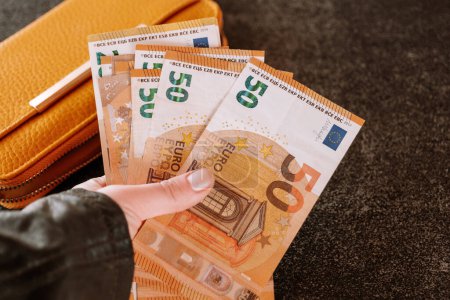 Photo for Wallet with money.Counting money. hand takes out euro bill from the wallet. Earnings and spending in the Eurozone. - Royalty Free Image
