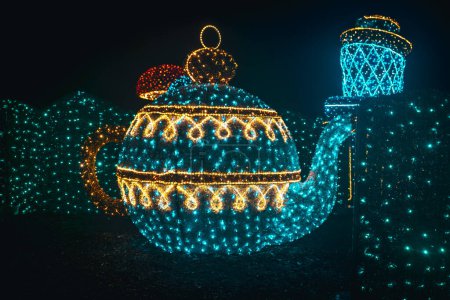 Photo for Installation of garlands.Shining teapot decoration.Glowing Christmas figures from garlands in the dark.Installation with garlands. - Royalty Free Image