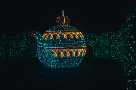 Photo for Christmas installation of garlands.Shining teapot decoration.Glowing Christmas figures from garlands in the dark. - Royalty Free Image