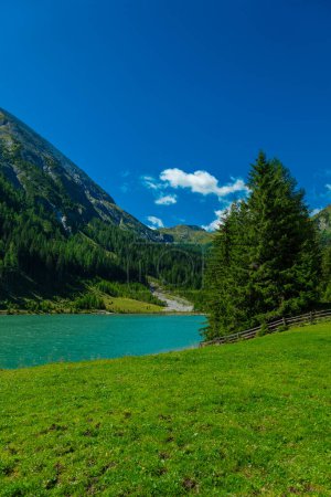 Foto de Lago de montaña Schlierersee, Lungau Austria.Transparent agua verde del lago sobre fondo cielo azul.Hermoso paisaje de montaña y lago - Imagen libre de derechos