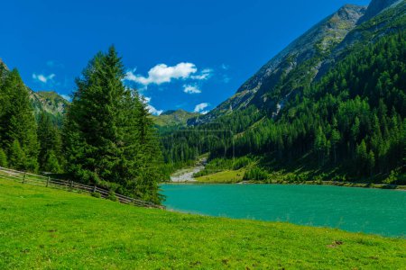 Foto de Pico de montaña y agua verde transparente del lago de montaña en el cielo azul con fondo de nubarras.Schlierersee, Lungau Austria. Hermoso paisaje de montaña y lago - Imagen libre de derechos