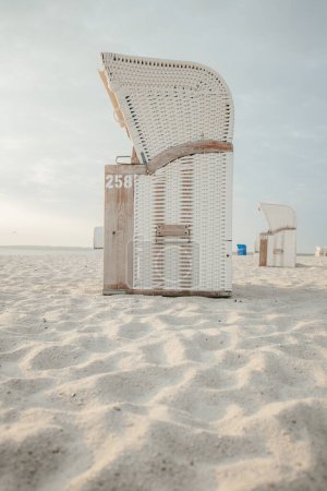 Vacation on the North Sea. Beach cabins on white sand. Beach wicker baskets on the sea coast of the northern sea. Beaches of the Frisian Islands in Germany. Sea summer mood. 
