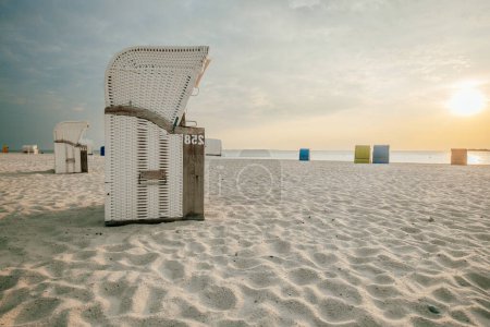 Beach cabins on white sand. Beach wicker baskets on the sea coast of the northern sea. Vacation on the North Sea. Beaches of the Frisian Islands in Germany. Sea summer mood. 