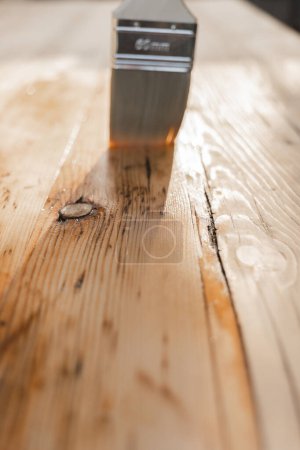  Impregnation of a wood with protective oil.Protecting the wooden surface from damage. Oil and varnish for wood.mans hand paints wooden boards with oil.