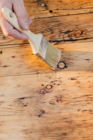  hand paints wooden boards.Oil and varnish for wood. Impregnation of a wood with protective oil. Impregnation of wood with oil.Protecting the wooden surface from damage.