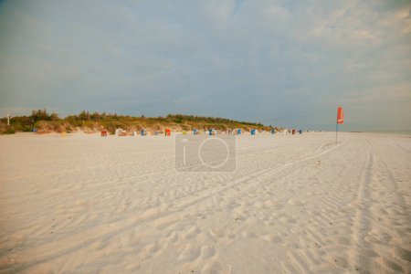Strand Sommer Hintergrund. Urlaub am Meer. Badeort.Weiße Sandstrände und Strandhütten auf weißem Sand.Strandsommerlaune.Urlaub an der Nordsee. Strände der Friesischen Inseln in Deutschland.