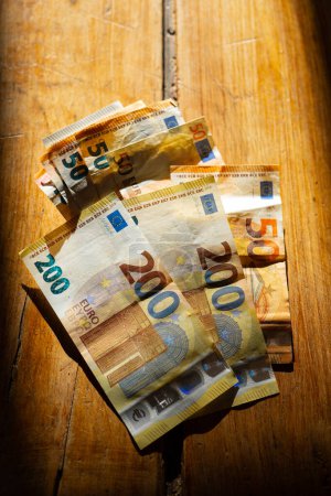 billetes de euros sobre una mesa en una franja de luz.Ingresos en los países europeos. Paquete de billetes en euros Pagos en efectivo en los países de la UE.Ganancias y gastos en la zona euro. 
