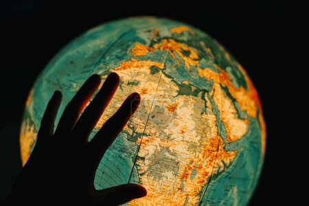 Viaje educativo: Globo luminoso y busca nombres de países.Explorando el mundo: La mano gira el globo brillante y busca nombres de países.Geografía interactiva.Búsqueda por país.