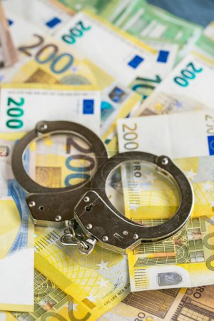Financial crimes and scams in Europe.economic crimes. Corruption and waste of the budget in the European Union.Handcuffs on euro bills .Arrest on bank accounts and property 