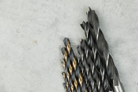 Foto de Cabezales de taladro inalámbricos de acero inoxidable en el fondo gris, cabezas de taladro de madera, pared y metal - Imagen libre de derechos