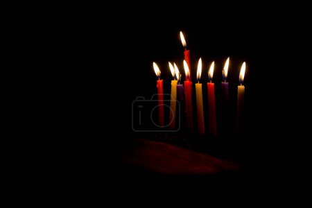 Foto de Andles on wooden table on night dark background with space for text. Jewish holiday Hanukkah - Imagen libre de derechos