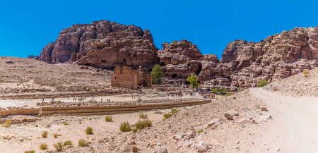 Photo for A panorama view across the main thoroughfare towards temple ruins and the western cliff face in the ancient city of Petra, Jordan in summertime - Royalty Free Image