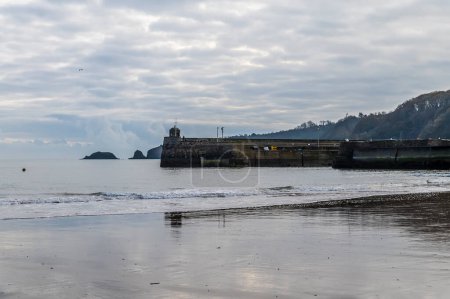 Photo for A view from the beach towards the harbour as the tide turns in Saundersfoot, Wales in winter - Royalty Free Image