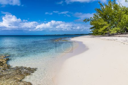 Foto de A view along a sandy beach with reef offshore on the island of Eleuthera, Bahamas on a bright sunny day - Imagen libre de derechos