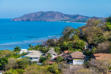 Blick am Strand entlang über den Ferienort Tamarindo auf die Bucht in Costa Rica in der Trockenzeit