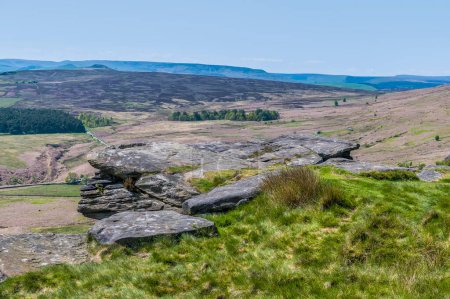 Foto de Una vista más allá de las losas de piedra de molino hacia el valle de abajo desde la escarpa Stanage Edge en el Peak District, Reino Unido en verano - Imagen libre de derechos