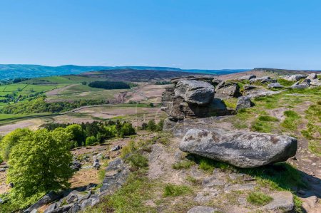 Foto de Una vista hacia los cantos rodados de piedra de molino en la parte superior de la escarpa Stanage Edge en el Peak District, Reino Unido en verano - Imagen libre de derechos